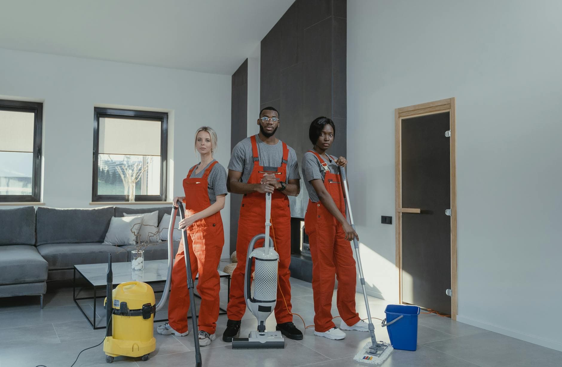 Your Business cleaning team in red uniforms ready to sanitize a modern Manhattan living room — Office Cleaning in Tottenville, Staten Island