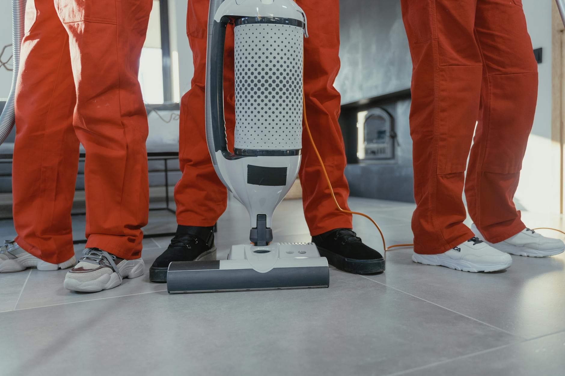 A team of professional Your Business cleaners in red uniforms using a vacuum in a New York home — Same-Day Cleaning in Douglaston, Queens