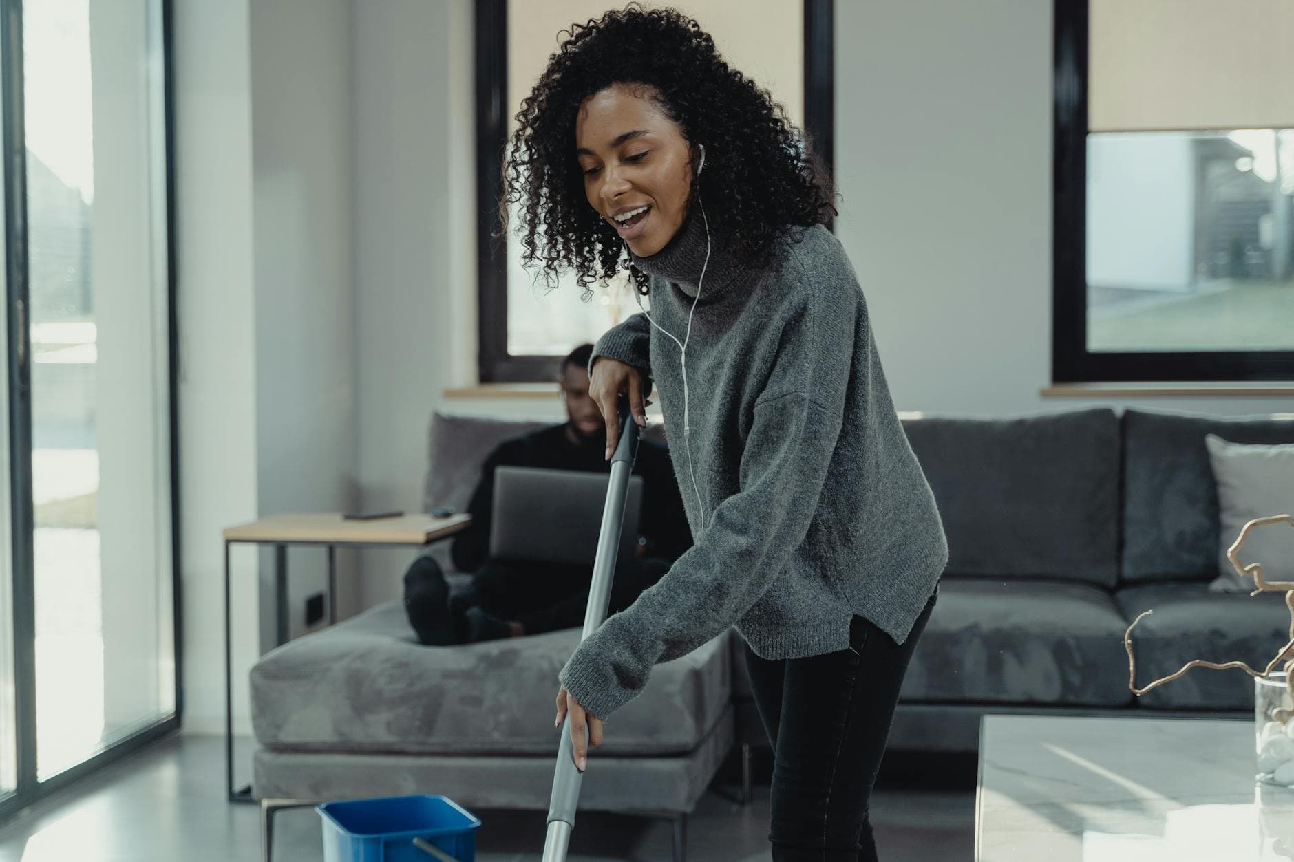 A professional house cleaner mopping the floor of a cozy New York City living room — Regular Apartment Cleaning in Atlantic Beach, Long Island