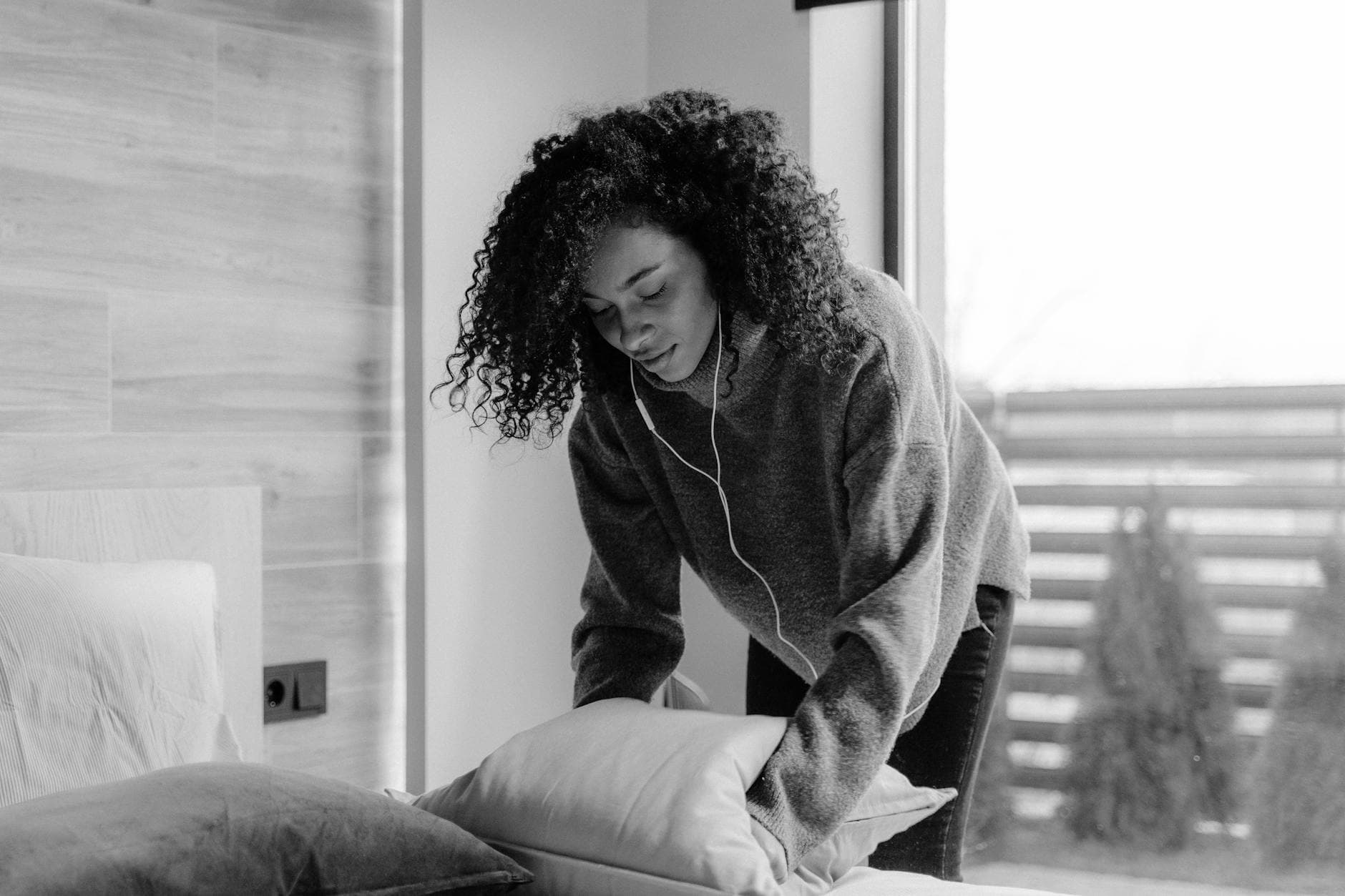 cleaning service making the bed in a bright, monochrome bedroom — Airbnb & Short-Term Rental Cleaning in Bedford-Stuyvesant, Brooklyn