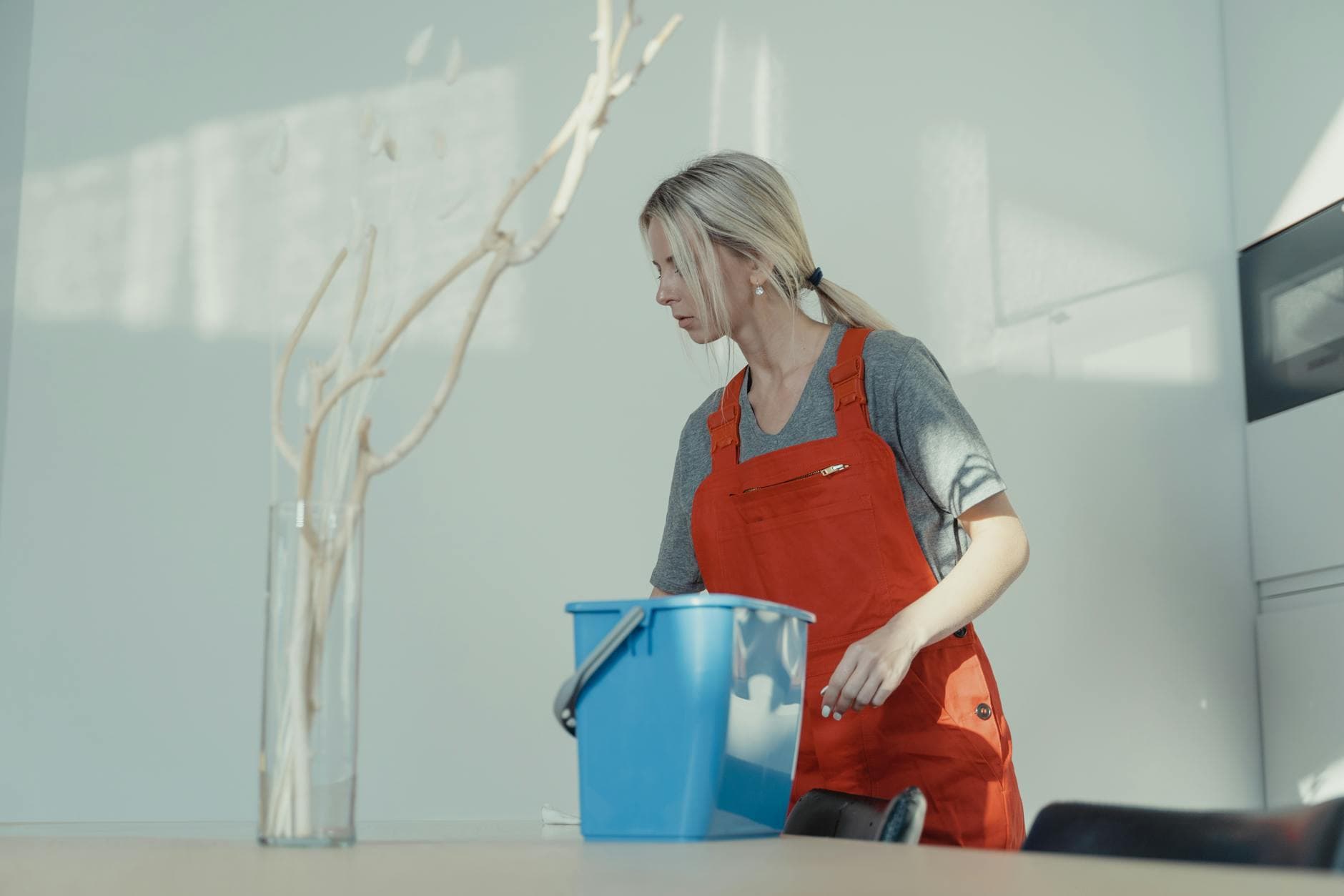 Professional cleaner from Your Business in red uniform cleaning an NYC apartment with a bucket — Post-Construction Cleanup in NYC